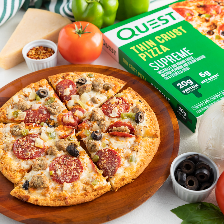 Quest Supreme Thin Crust Pizza Package staged with pizza on cutting board with toppings 